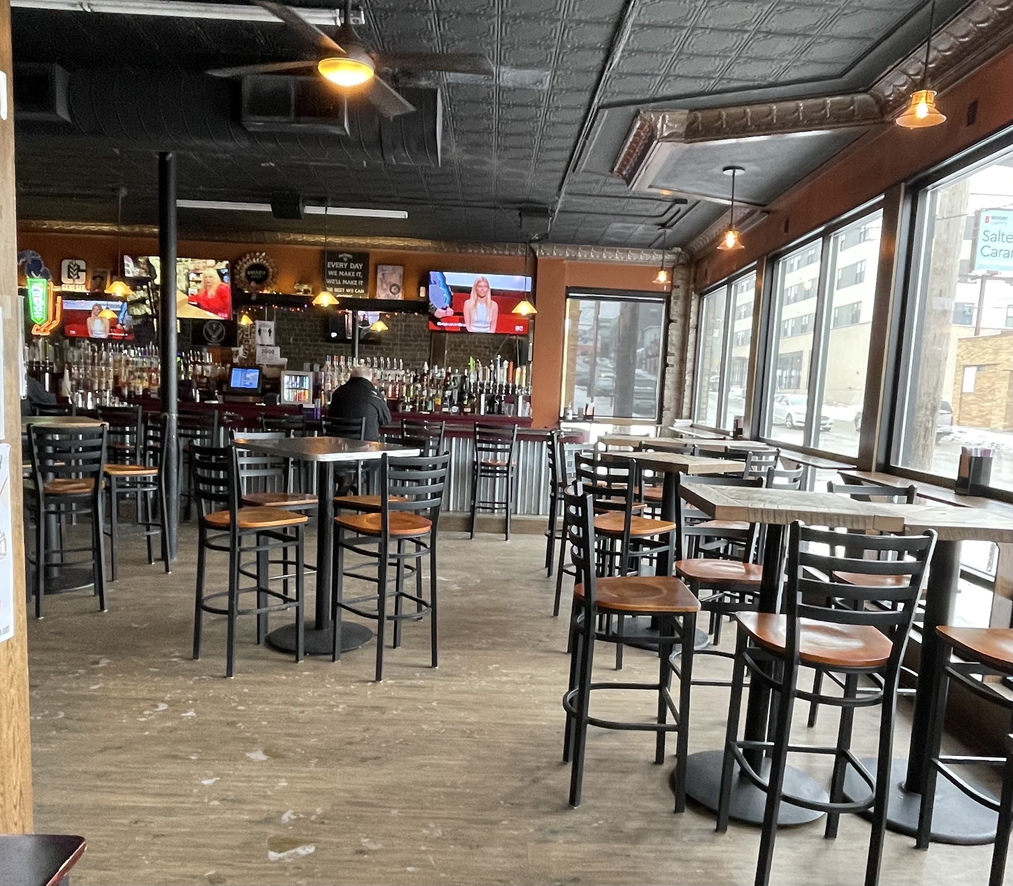 Duke's interior with high-top tables and tin ceiling